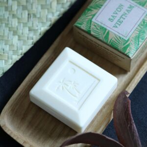 Organic bar soap displayed elegantly on a wooden tray with tropical design box.